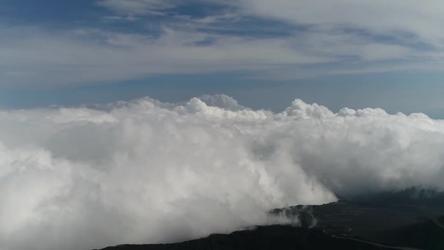 High altitude aerial footage turning left towards Mount Etna summit above clouds it is an active stratovolcano on the east coast of Sicily Italy in the Metropolitan City of Catania 4k resolution