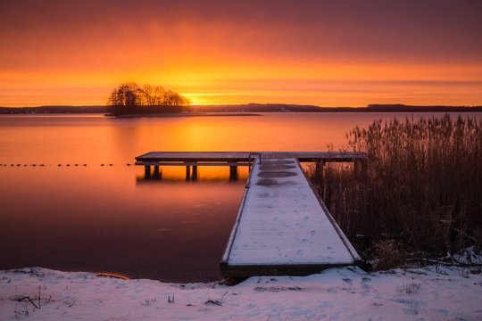 Sunrise over the Swiecajty lake and wooden footbridge near Wegorzewo, Masuria, Poland © Artur Bociarski