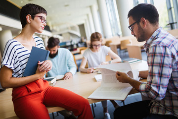Group of college students studying at library