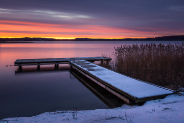 Sunrise over the Swiecajty lake and wooden footbridge near Wegorzewo, Masuria, Poland - 242274062
