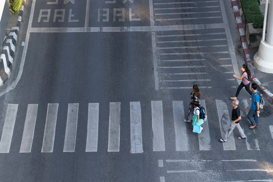Aerial view photo of people walk on street in the city over pedestrian crossing traffic road