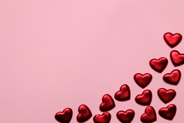 red hearts on a bright pink background. frame of hearts, top view with space for text