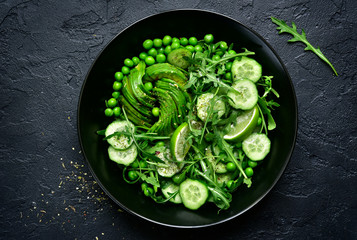 Green vegetables salad (sweet pea, avocado, arugula, cucumber).Top view.
