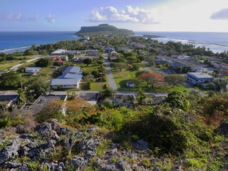 Wide view overlooking Songsong village with the Cake Mountain in the distance facing the ocean, Rota, Northern Mariana Islands.