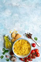 Traditional organic ingredients of italian cuisine : pasta, tomato, garlic, olive oil, parmesan cheese and basil.Top view with copy space.