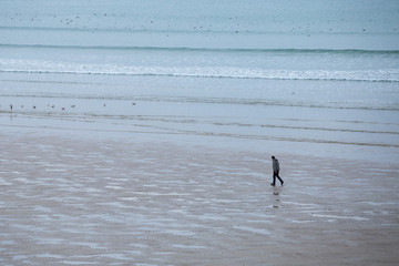 Fototapeta na wymiar homme seul marchant sur la plage