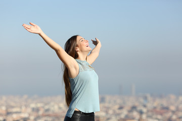 Excited woman raising arms celebrating vacation