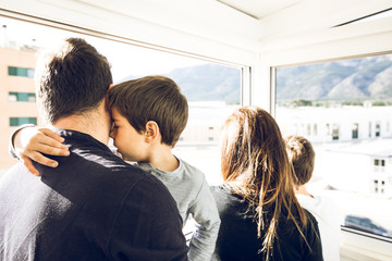 A family looking out the window of the house. A happy and united family