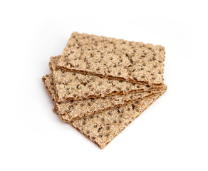 A pile of four crunchy wheat rye brown crackers, isolated on white background. Healthy food concept.