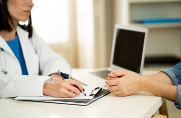Fototapeta premium Close up of woman doctor and patient having consultation in hospital room