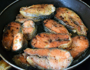 Fried red fish in a pan. Pieces of chum salmon in the spices. Expensive fish.