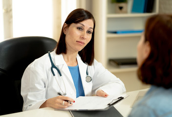 Female doctor listening to woman patient explaining her symptoms and health problems