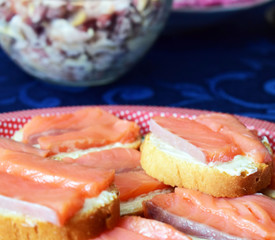 Festive snacks and salad on the table. Sandwiches with butter and red fish. Salmon fillet.