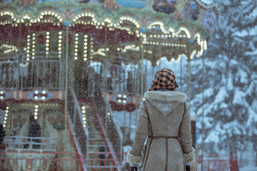 Woman looks at the Victorian carousel on a snowy day