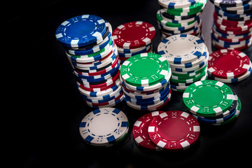 Colorful casino chips on dark background closeup