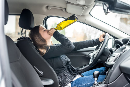 Woman Drinking Alcohol While Driving A Car