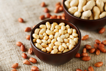Peanuts in the shell and peeled closeup in a cup