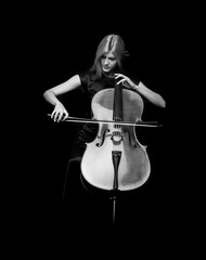 Young girl playing the cello on isolated black background