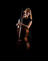 Young girl playing the cello on isolated black background