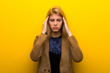 Blonde girl on vibrant yellow background unhappy and frustrated with something