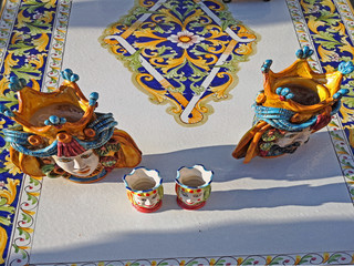 Italy, Ravenna, ceramics table and table decorations display at the Sunday downtown open market. 