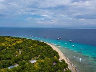 Obraz premium Aerial view of tropical beach on the island Malcapuya. Beautiful tropical island with sand beach, palm trees. Tropical landscape with shore and boats. Palawan, Philippines.