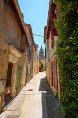 Street in Arles with old cute houses and church. Provence region south France.