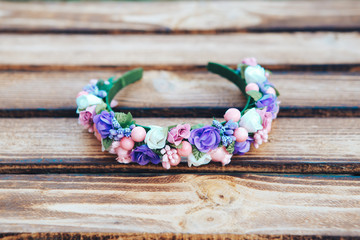 Handmade hoop purple flowers. Red and white hair band on wooden background