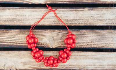 Red beads handmade. Wooden background. Top view