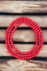 Red beads handmade. Wooden background. Top view. Ukrainian style