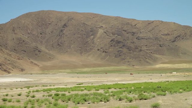 Long still showing a heat shimmer of the Great Salt Desert, or Dash-e Kavir in Iran. The heat haze creates a mirage across the desert.