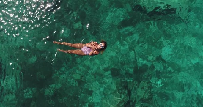 Summer image of beautiful girl swimming and lying on the back in the turquese sea water. Slim tanned body. Amazing sea landscape. Happy vacation and relaxing. Cyprus Green bay.