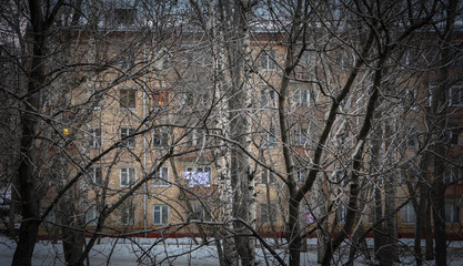 view of a residential building through winter trees