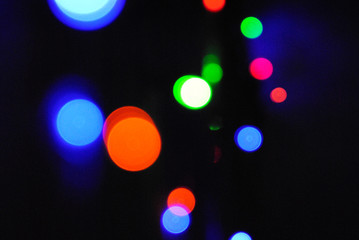 Christmas background, garland lights, glass ball, toys, glare night. New Year's toys and ornaments background theme.