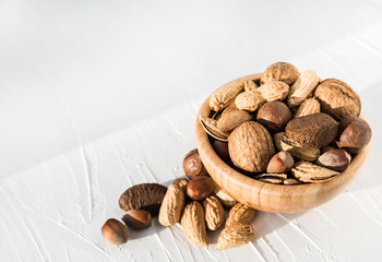 Nuts in an assortment on a plate on a white background. Copy space. Healthy food