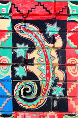 Fragment of graffiti drawings. The old wall decorated with paint lizards in the style of street art culture. Colored background texture