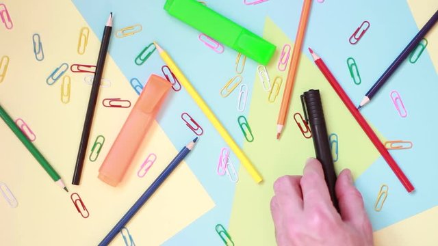 Markers and pencils over multicolored paper