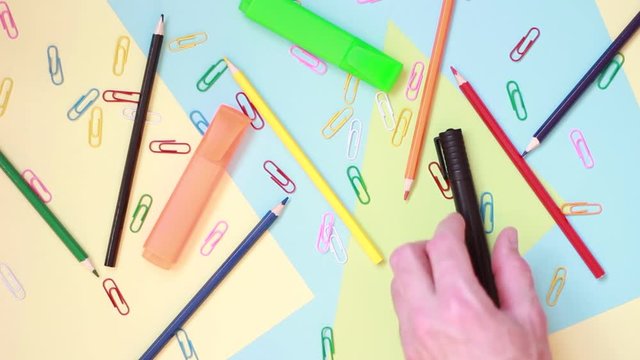 Taking markers from pile of stationery