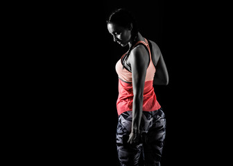 Sport woman on dark background making weightlifting