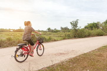 Obraz premium Woman riding bicycle relax in a country road.
