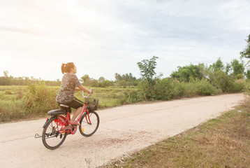 Obraz premium Woman riding bicycle relax in a country road.