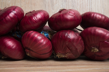 Purple onions on a wooden background. Bunch of onions. Yalta onions.