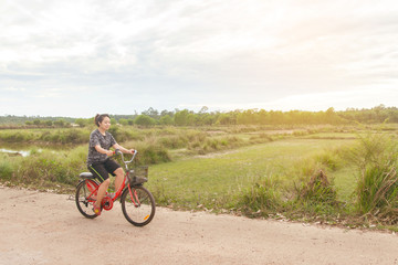 Obraz premium Woman riding bicycle relax in a country road.