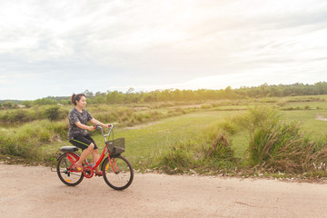 Woman riding bicycle relax in a country road.