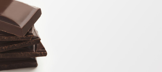 Stack of dark chocolate bars on white background