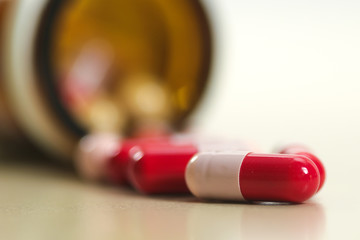 Red and pink antidepressant capsule and glas bottle