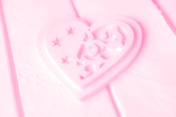 Pink heart on a white wood background.