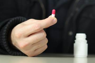 Man takes the antidepressants red and pink capsule