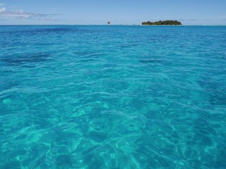 Wide shot of sparkling blue waters of Saipan lagoon, with Managaha Island in the background. Managaha is a favorite day trip destination for tourists from all parts of the world. 