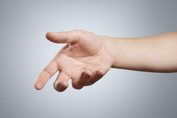 Hand holding or giving something on grey background